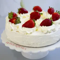 En krämig tres leches-tårta med vispgrädde och färska jordgubbar, perfekt för ett sommarfika.