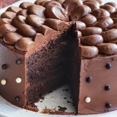 En saftig chokladtårta med chokladfrosting och dekorationer av chokladkulor. Perfekt för alla som älskar choklad och letar efter ett gott chokladtårta recept.
