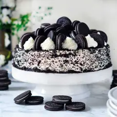 En imponerande oreo tårta, täckt med krossade kakor och dekorerad med hela oreos och fluffig grädde. Perfekt för alla kakälskare!
