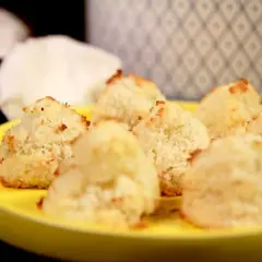 Saftiga kokostoppar recept på en gul tallrik. Dessa små, gyllene bakverk ser utsökta ut!