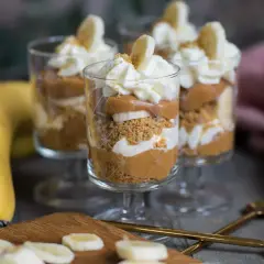 Tre glas med banoffee paj i lager av kexsmulor, kolasås, banan och grädde. Garnerad med bananskivor och strössel.