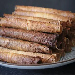 En hög med gyllenbruna rullrån på en tallrik. Perfekt för ett enkelt rullrån recept.