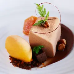 En elegant choklad havtorn dessert med en mousse, sorbet, kanderade nötter och en chokladsås.