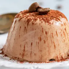 Krämig kaffepannacotta, pudrad med kakao och toppad med kaffebönor och mynta. En perfekt dessert.