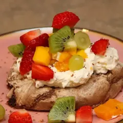 En chokladpavlova med vispgrädde och färsk frukt som jordgubbar, kiwi och mango. En härlig dessert!