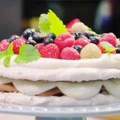 En vacker marängtårta med grädde och bär, perfekt för ett somrigt margaretatårta recept.