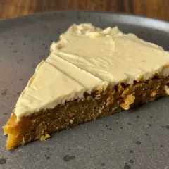 En bit saftig kaka med krämig glasyr, perfekt för att baka med farinsocker.