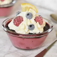 En krämig dessert med bär och mascarpone, toppad med vispgrädde, hallon, blåbär och en citronskiva. Perfekt att baka till fikat!