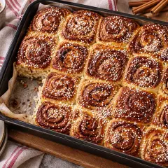 Nybakade kanelbullar i långpanna, strösslade med pärlsocker. En perfekt fika!