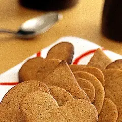En hög med pepparkakor, perfekta att förvara till jul. En sked ligger redo för att njuta av dem.