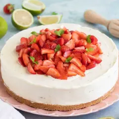 En krämig vit choklad cheesecake toppad med färska jordgubbar och mynta. En perfekt sommardessert!