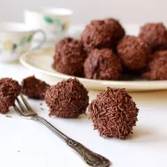 Chokladbollar, perfekta för ett arraksbollar recept. En gaffel ligger bredvid en av de chokladöverdragna godsakerna.