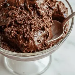 En sked tar en tugga av krämig chokladmousse i en glasskål. Perfekt för ett enkelt chokladmousse recept.