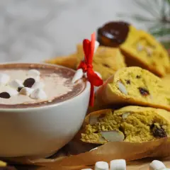 En kopp varm choklad med marshmallows och saffransbiscotti med mandel, perfekt för en mysig stund.