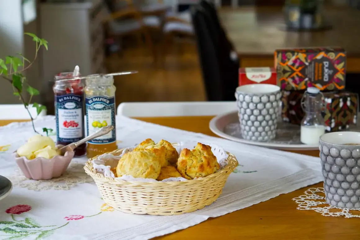 En härlig eftermiddagste med nybakade scones, sylt, smör och te.