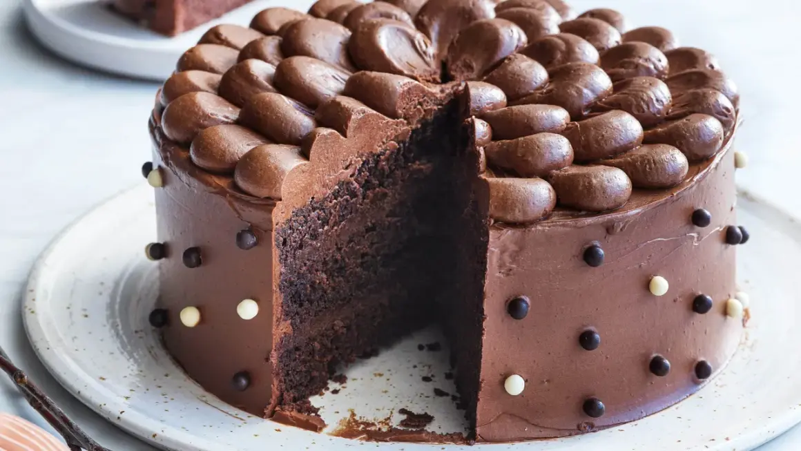 En saftig chokladtårta med chokladfrosting och dekorationer av chokladkulor. Perfekt för alla som älskar choklad och letar efter ett gott chokladtårta recept.