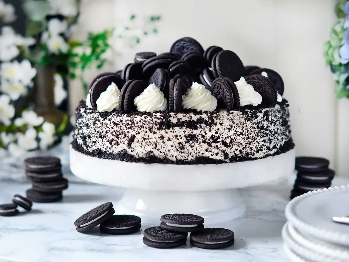 En imponerande oreo tårta, täckt med krossade kakor och dekorerad med hela oreos och fluffig grädde. Perfekt för alla kakälskare!