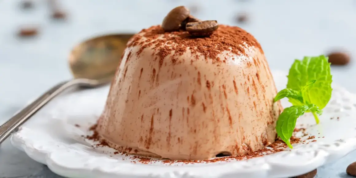 Krämig kaffepannacotta, pudrad med kakao och toppad med kaffebönor och mynta. En perfekt dessert.