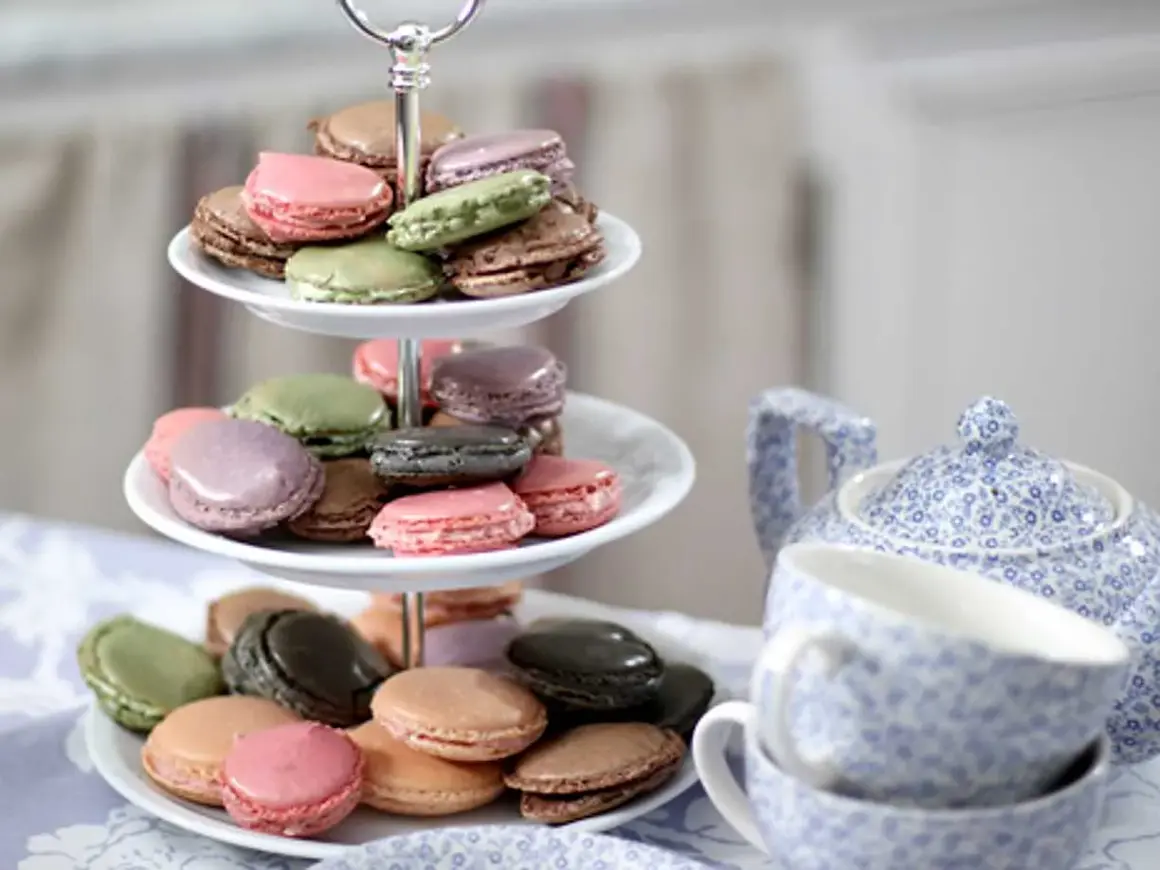 Färgglada macarons på ett tårtfat, redo att avnjutas. Ett perfekt macarons recept för fika.