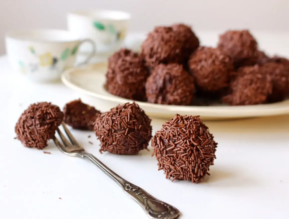 Chokladbollar, perfekta för ett arraksbollar recept. En gaffel ligger bredvid en av de chokladöverdragna godsakerna.