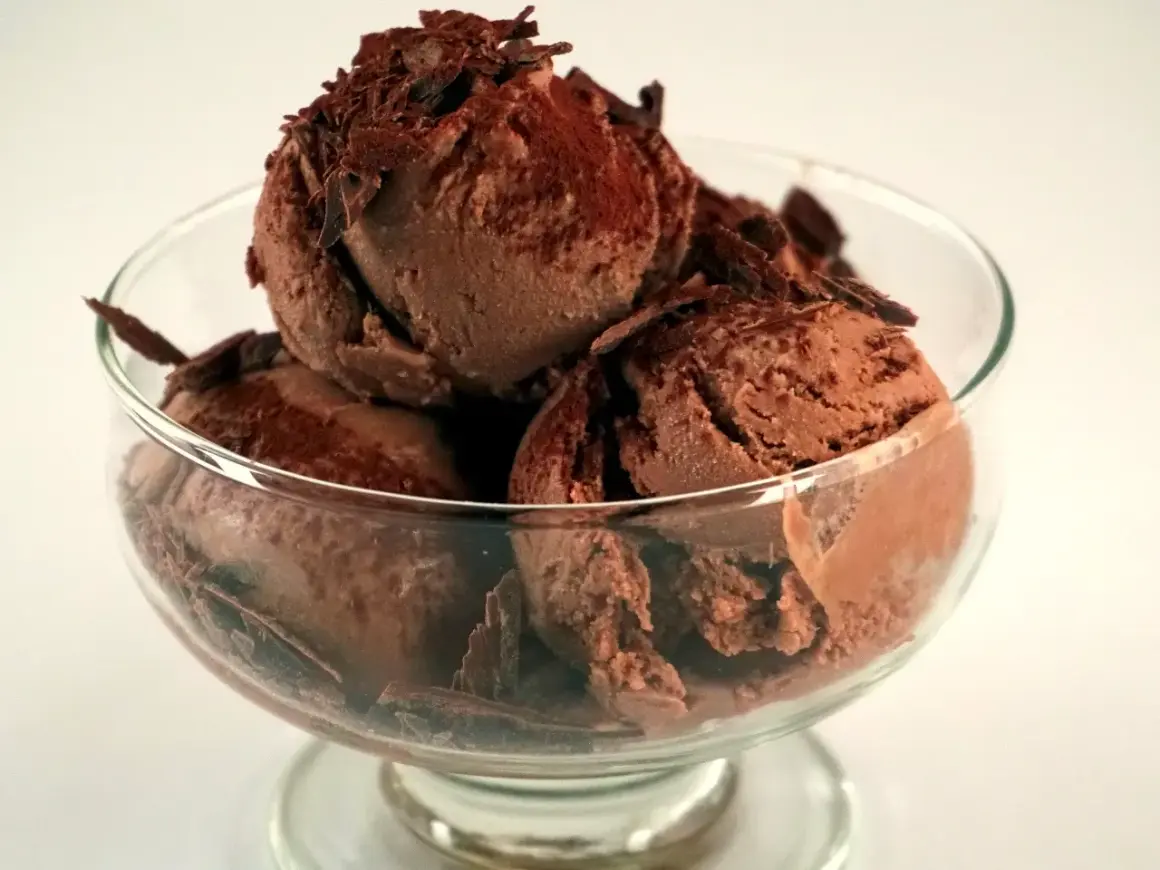 En skål med krämig chokladglass, toppad med chokladspån. Perfekt för ett enkelt chokladglass recept.