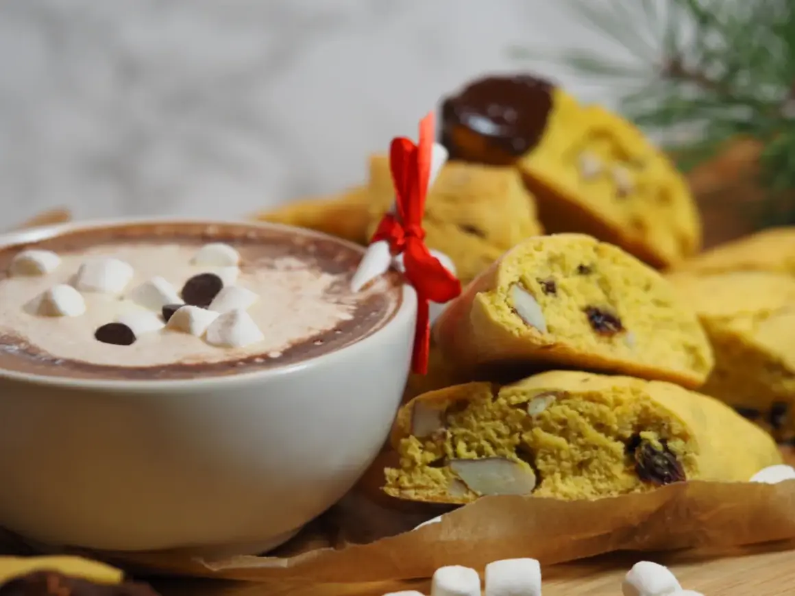 En kopp varm choklad med marshmallows och saffransbiscotti med mandel, perfekt för en mysig stund.
