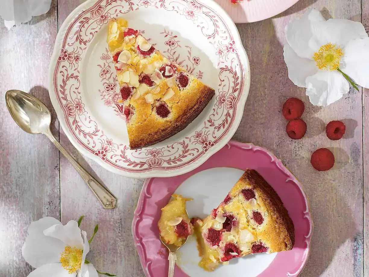 En bit hallon- och mandelkaka p&aring; en tallrik, perfekt f&ouml;r ett enkelt vit choklad recept.