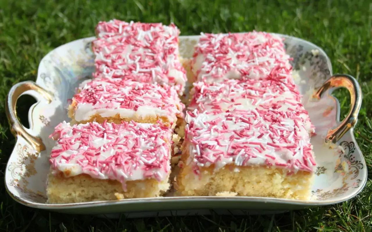 En härlig långpannekaka med vit glasyr och rosa strössel, perfekt att baka till fikat.