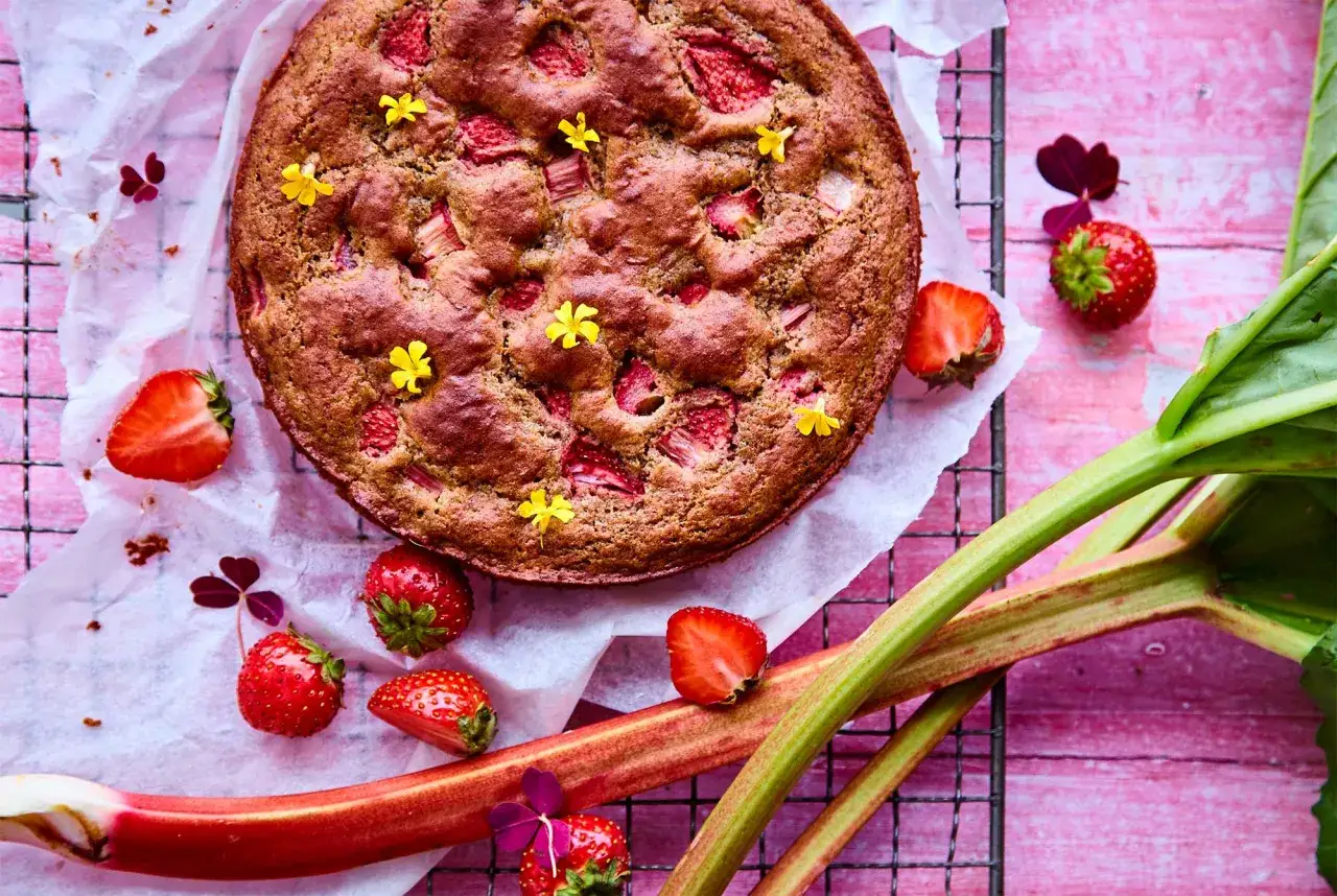 En saftig rabarberkompott t&aring;rta med f&auml;rska jordgubbar och sm&aring; gula blommor. Perfekt f&ouml;r fikat!