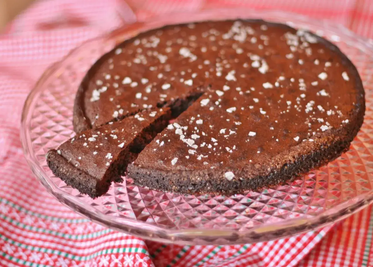 Chokladkaka med espressopulver f&ouml;r bakning, pudrad med florsocker, serverad p&aring; ett glasfat.