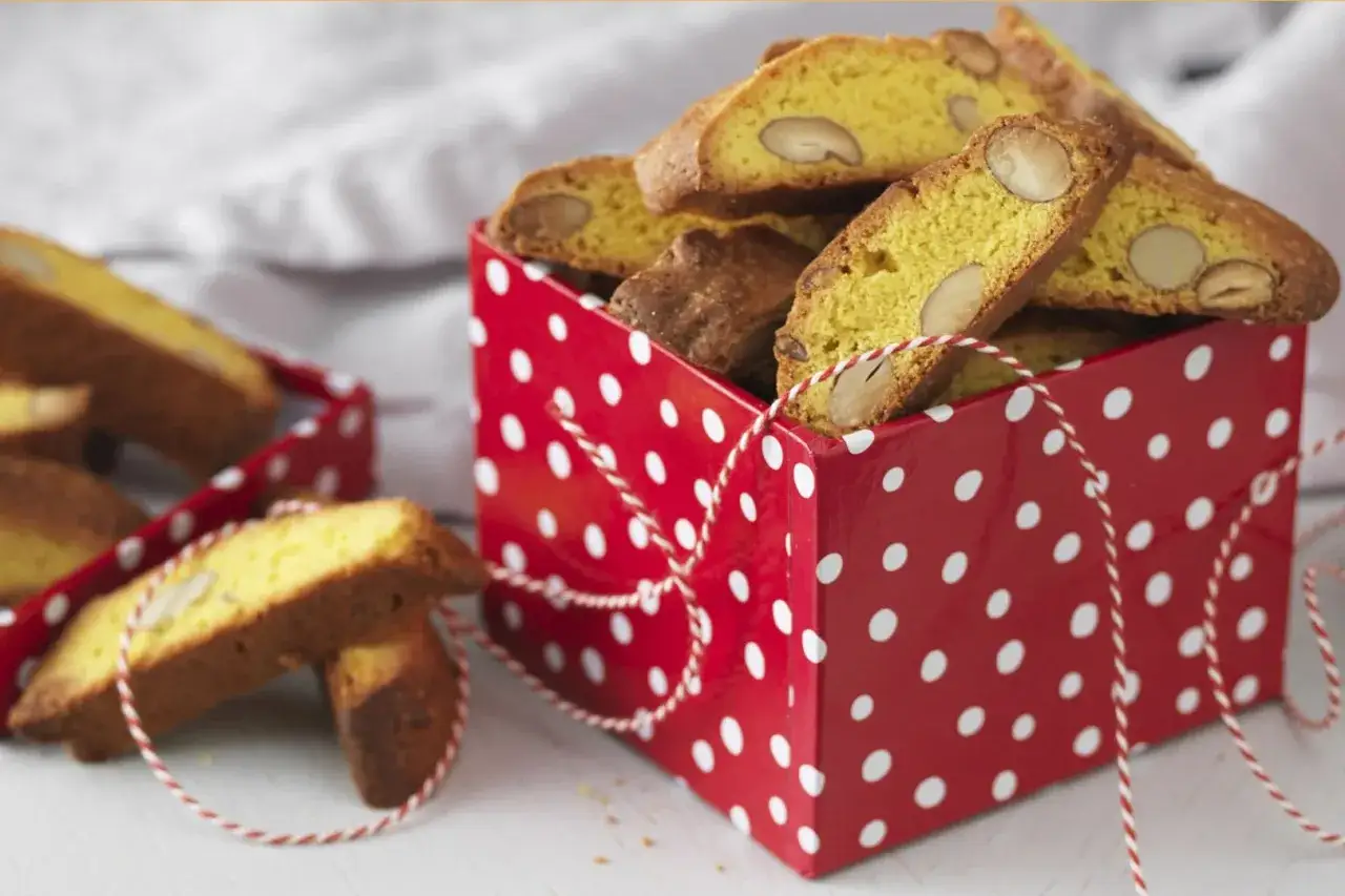 En röd prickig låda fylld med saffransbiscotti med mandel. En härlig julig present!