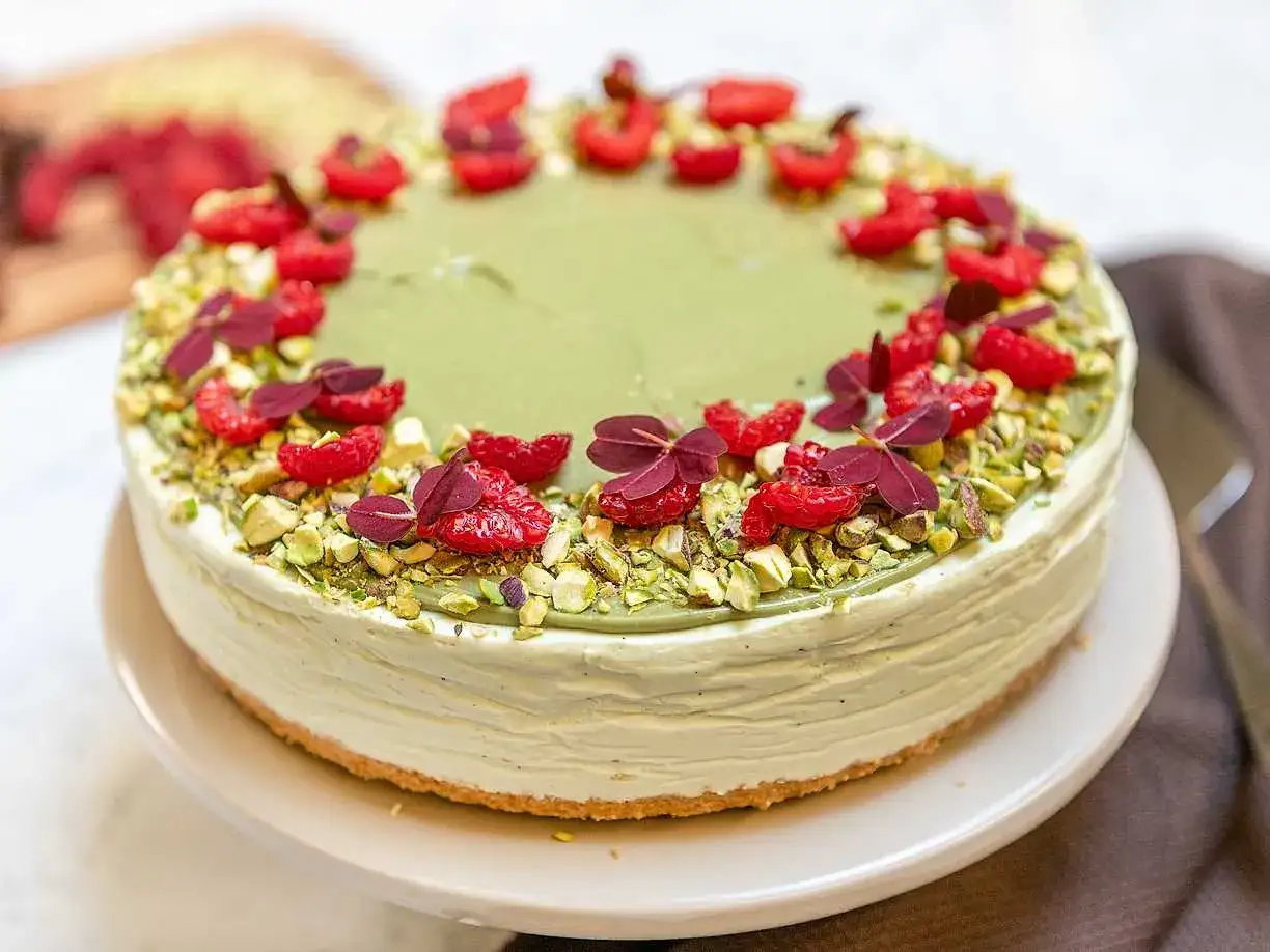 En l&auml;cker pistage cheesecake med hallon och n&ouml;tter.