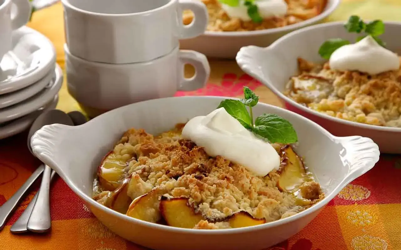 En härlig dessert att baka med nektariner, serverad med en klick grädde och mynta.