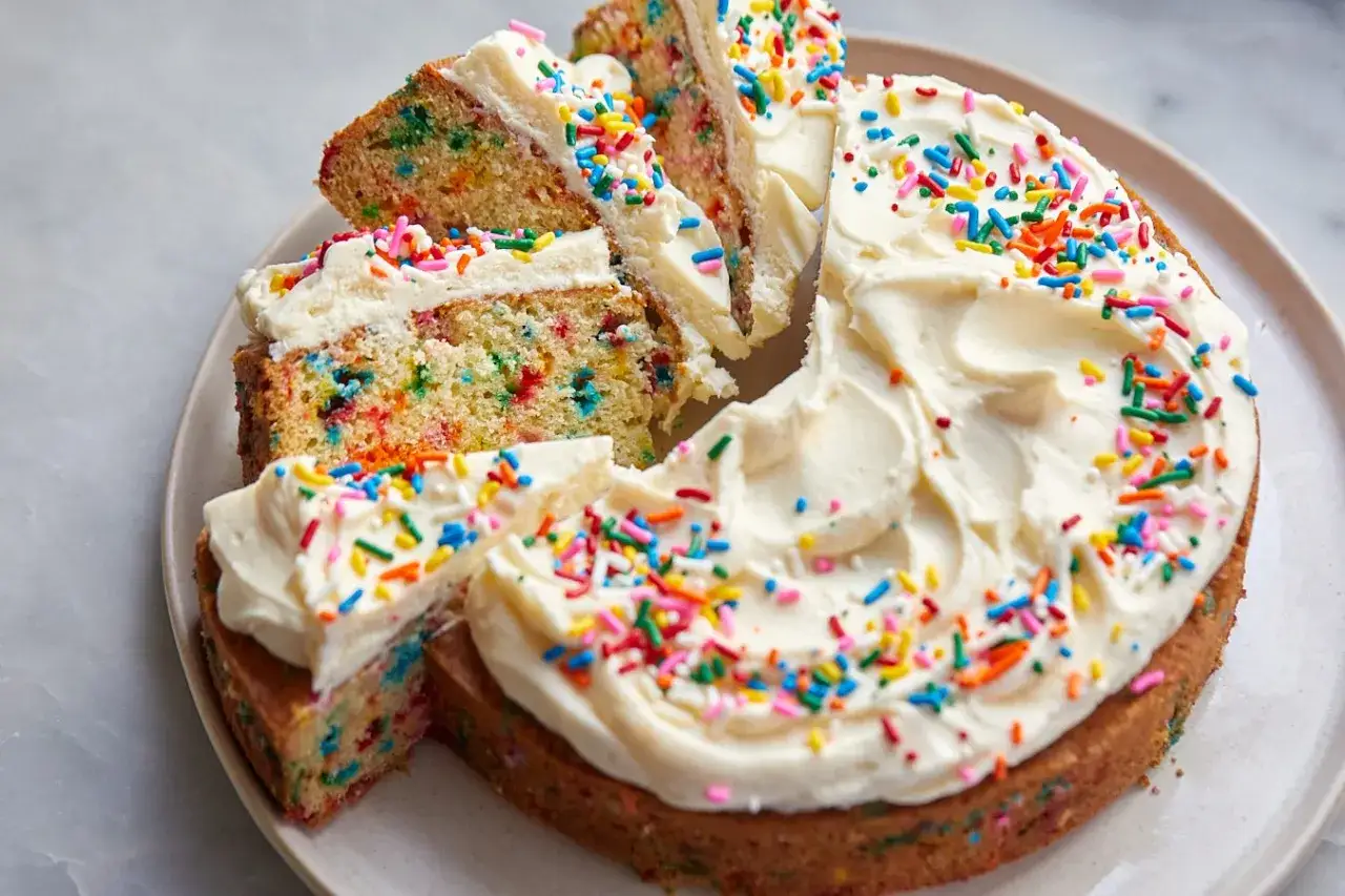 En h&auml;rlig funfetti t&aring;rta med vit frosting och f&auml;rgglada str&ouml;ssel. Perfekt f&ouml;r firande!