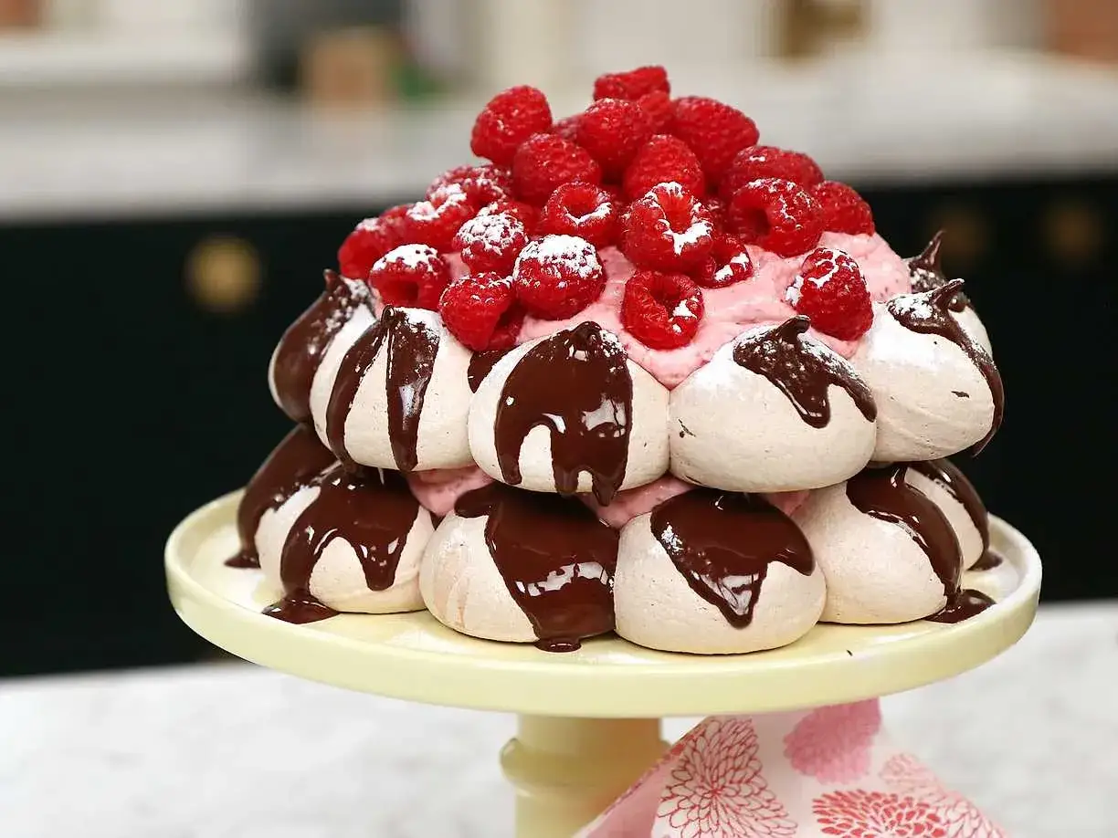 En magnifik pavlova choklad staplad med maränger, hallon och chokladsås.
