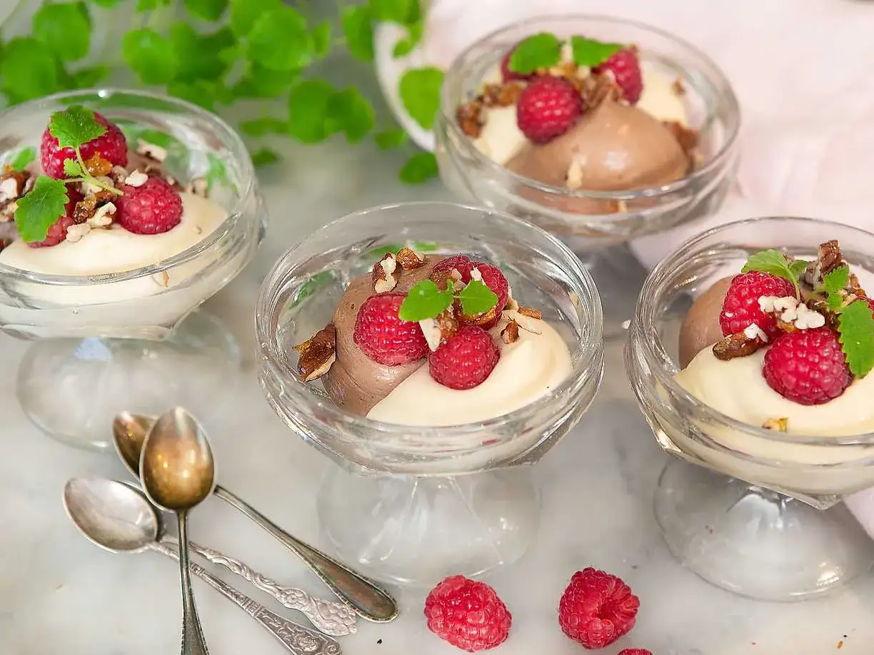 Ljuvlig choklad- och vaniljmousse i glas, toppad med hallon och n&ouml;tter. Ett perfekt recept f&ouml;r en festlig dessert!